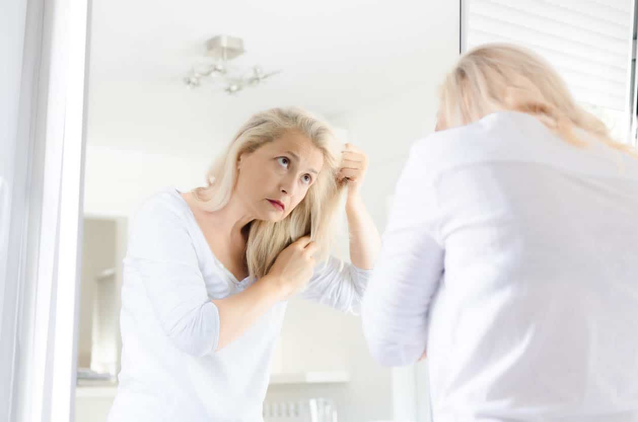 Woman Looking Hair In A Mirror