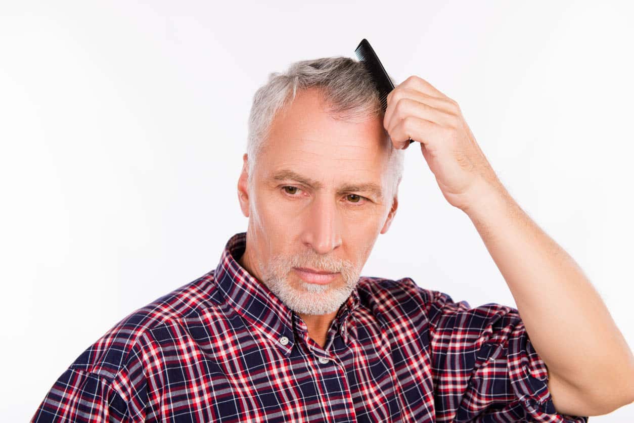 Homme âgé gris bouleversé peignant ses cheveux