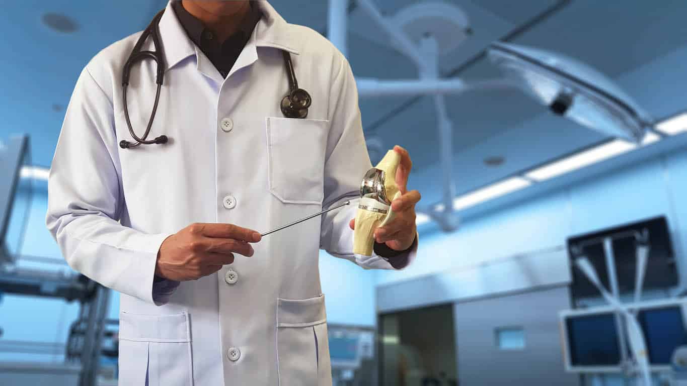 Docteur orthopédique affichant le modèle du remplacement total de genou