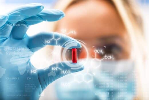 Young Attractive Female Scientist Holding A Red Transparent Pill