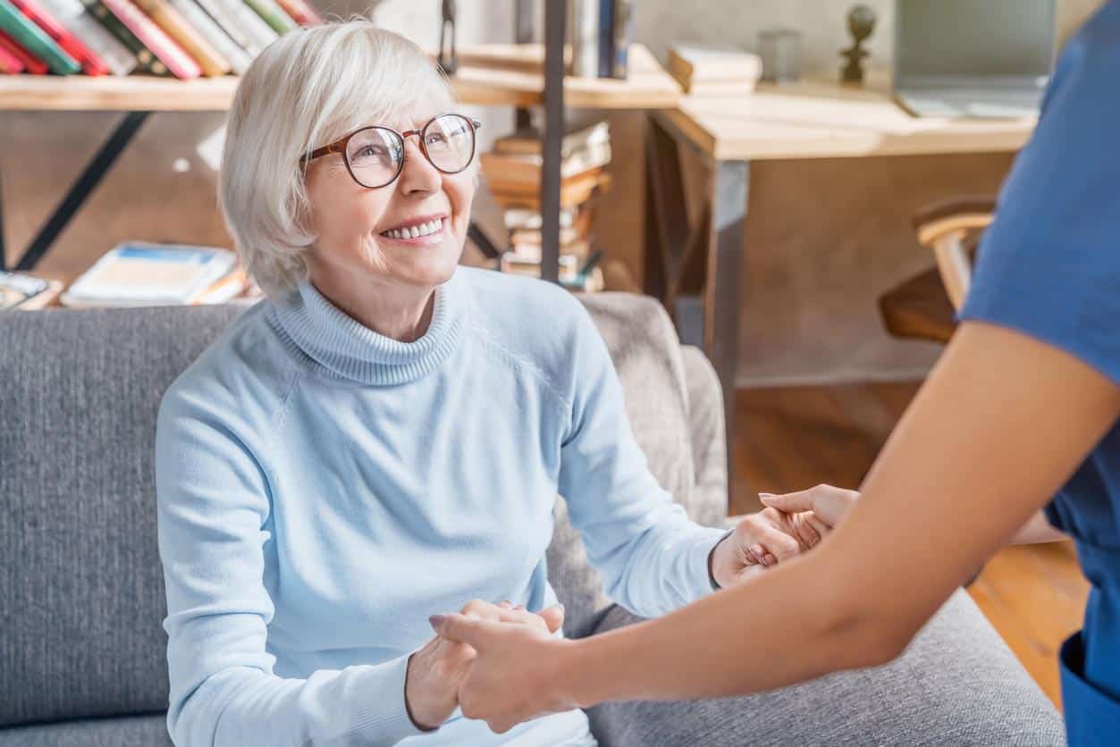 soignant professionnel féminin prenant soin de la femme âgée à la maison