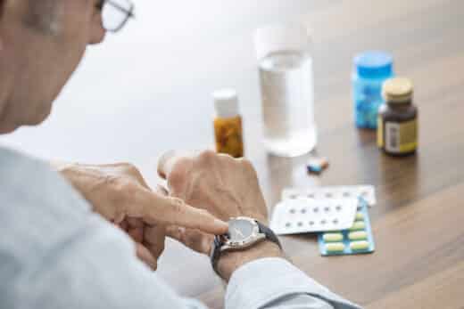 homme agé qui regarde sa montre pour prendre ses médicaments