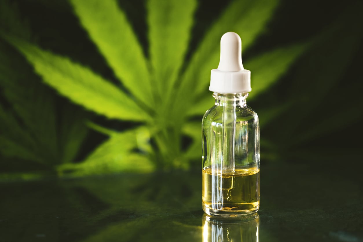 Glass Bottle With Cbd Oil On Black Background With Marijuana Leaf