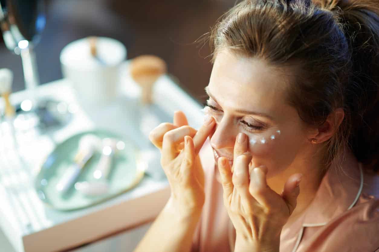 Female At Modern Home In Sunny Winter Day Applying Eye Cream