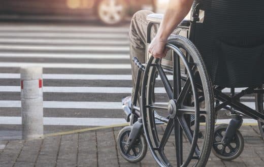 senior en fauteuil roulant en traversant la route