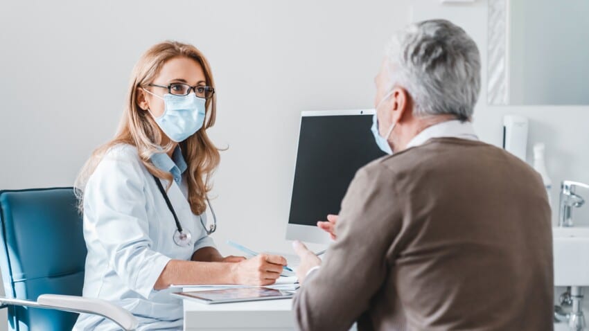 femme medecin qui porte un masque devant son patient pour faire un check up