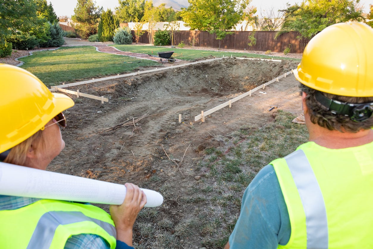 ravailleurs masculins et féminins donnant sur le chantier de Construction de piscine