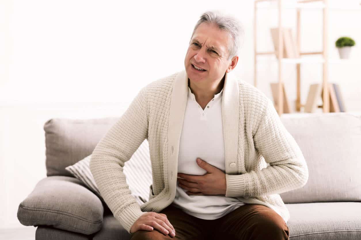 Mal au ventre. Homme senior touche son ventre souffrant de la douleur de la gastro