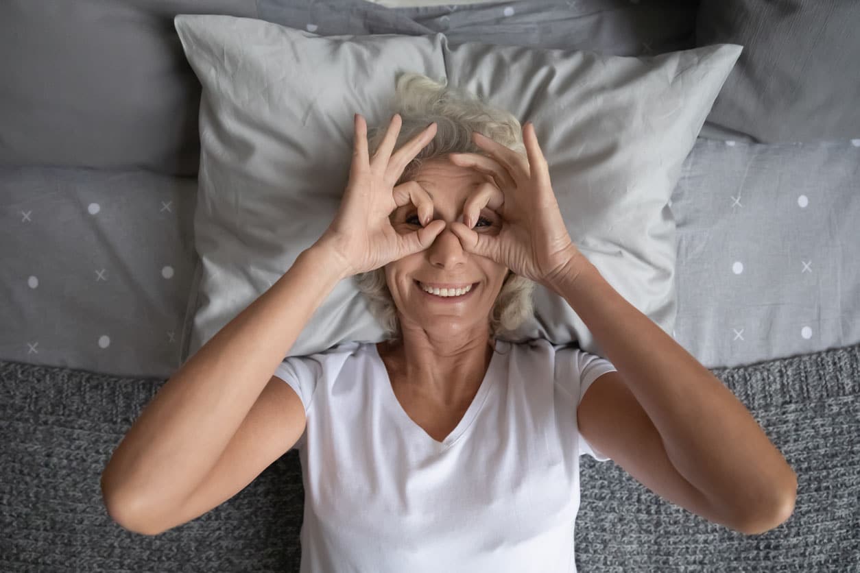 Femme âgée dans son lit heureuse