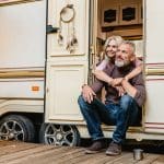 Couples heureux âgés s’asseyant dans la porte de camping car