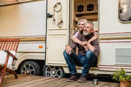 Couples heureux âgés s’asseyant dans la porte de camping car