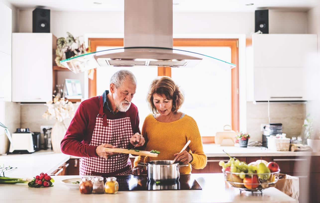 Couple de personnes âgées préparer une soupe dans la cuisine