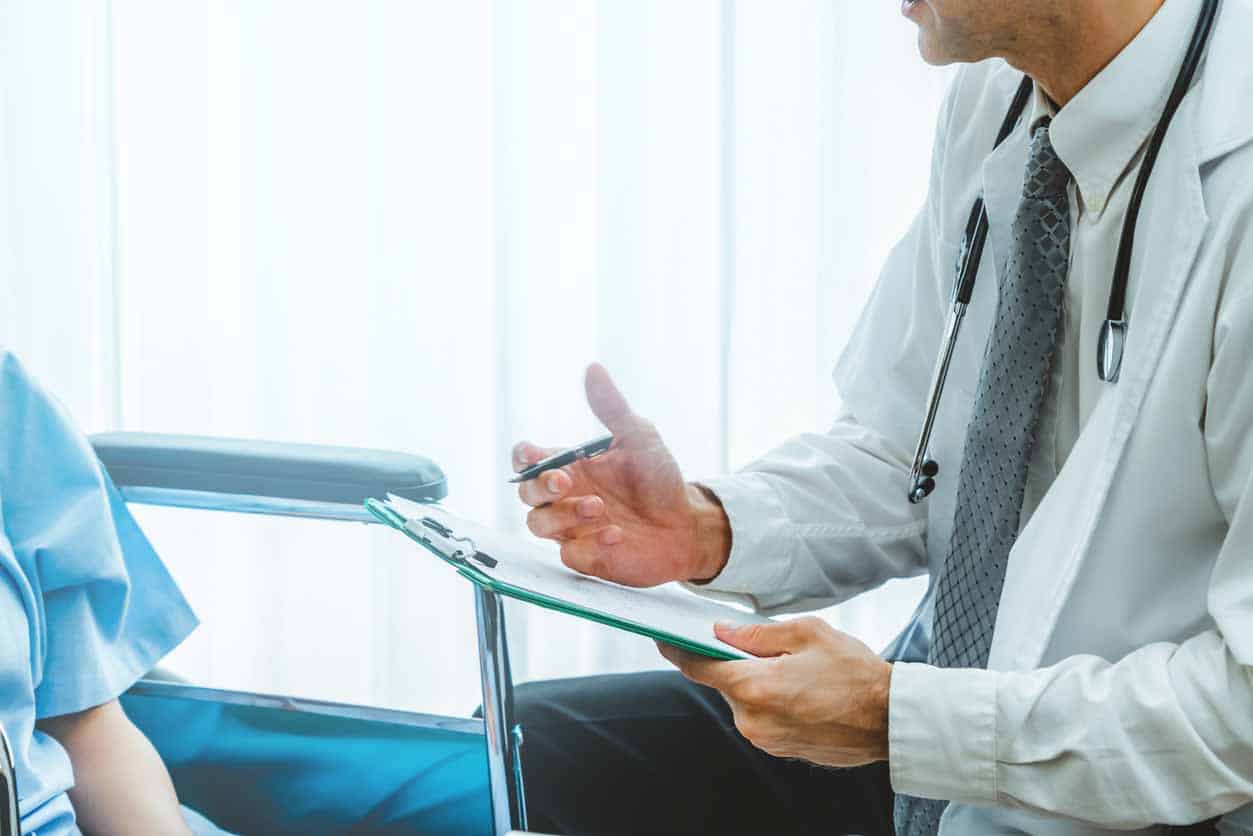 Docteur dans l’uniforme professionnel examinant le patient à l’hôpital