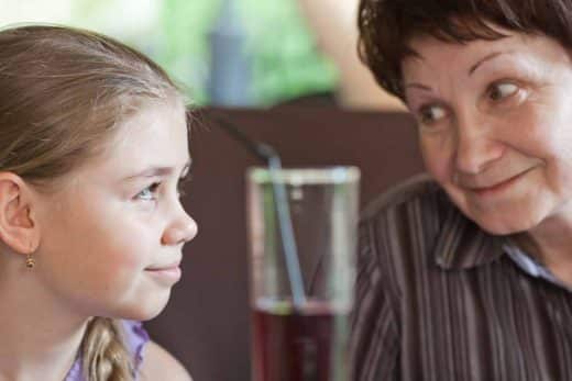 grand mere et sa petite fille devant un verre de jus de raisin