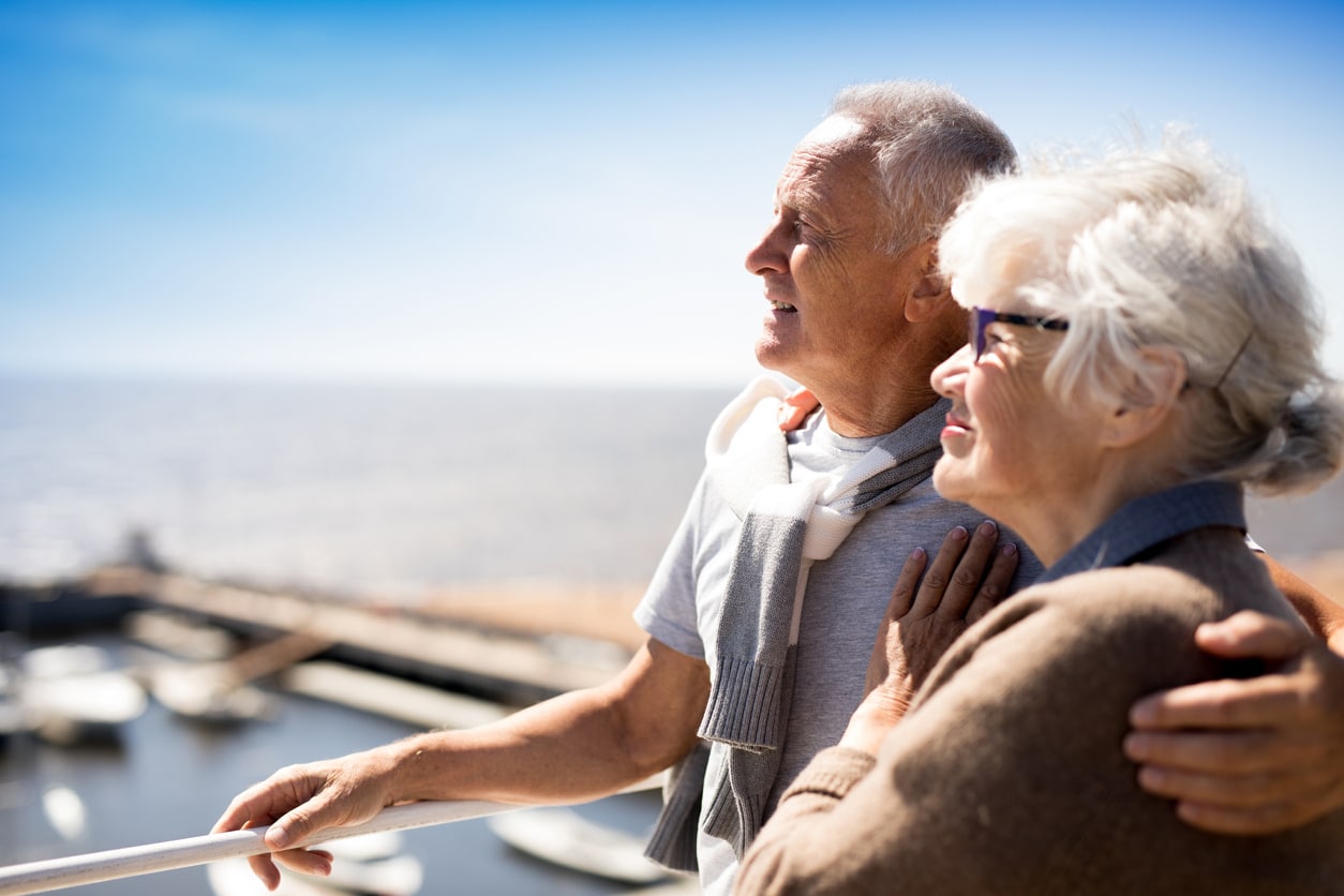 deux seniors sur un bateau de croisiere qui regardent le paysage