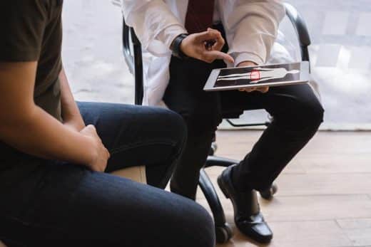 Homme médecin et patient atteint de cancer testiculaire discutent sur le rapport de test de cancer