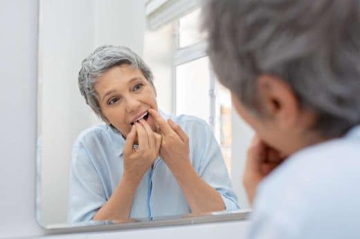 Femme Senior Qui Se Passe Du Fil Dentaire