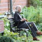 femme agée sur un banc dans une maison de retraite