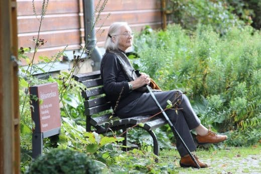 femme agée sur un banc dans une maison de retraite